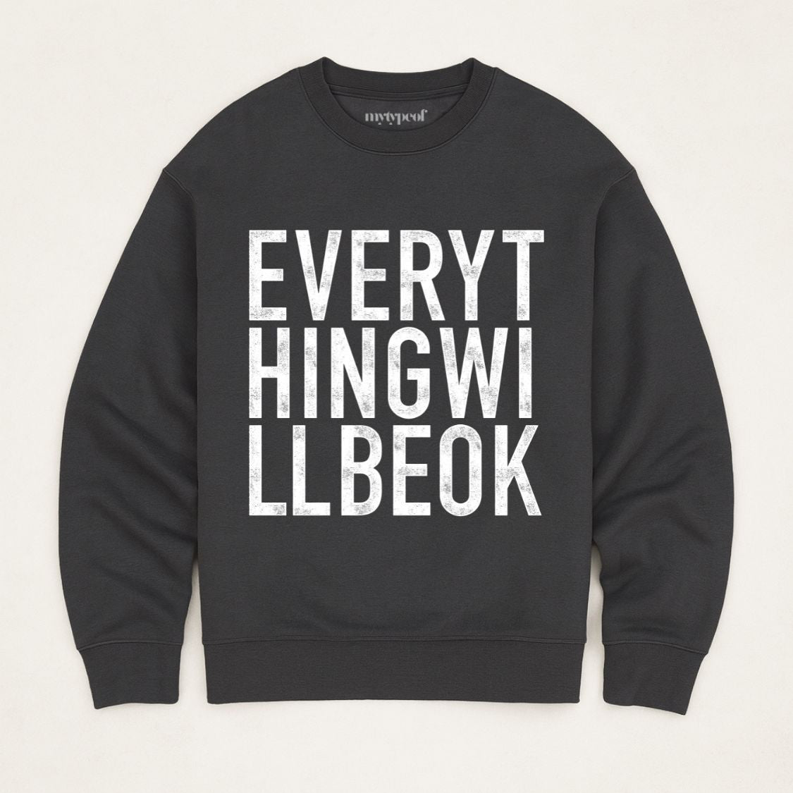 Black oversized, organic unisex sweatshirt with bold vintage style typography in white saying "Everything will be ok"  Photographed  as a flay lay on a plain background. 