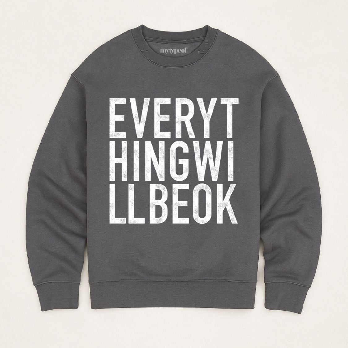 Iron Grey coloured  oversized, organic unisex sweatshirt with bold vintage style typography in white saying "Everything will be ok"  Photographed  as a flay lay on a plain background. 