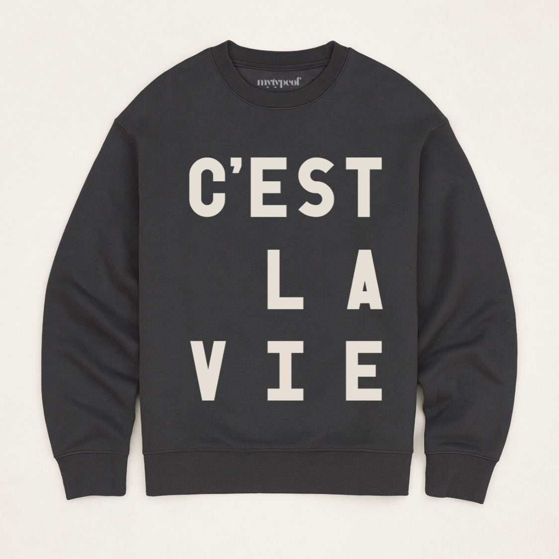Black, typographic sweatshirt, with 'C'est La Vie' design. unisex, oversized sweatshirt, photographed  as a flay lay on a plain background. 