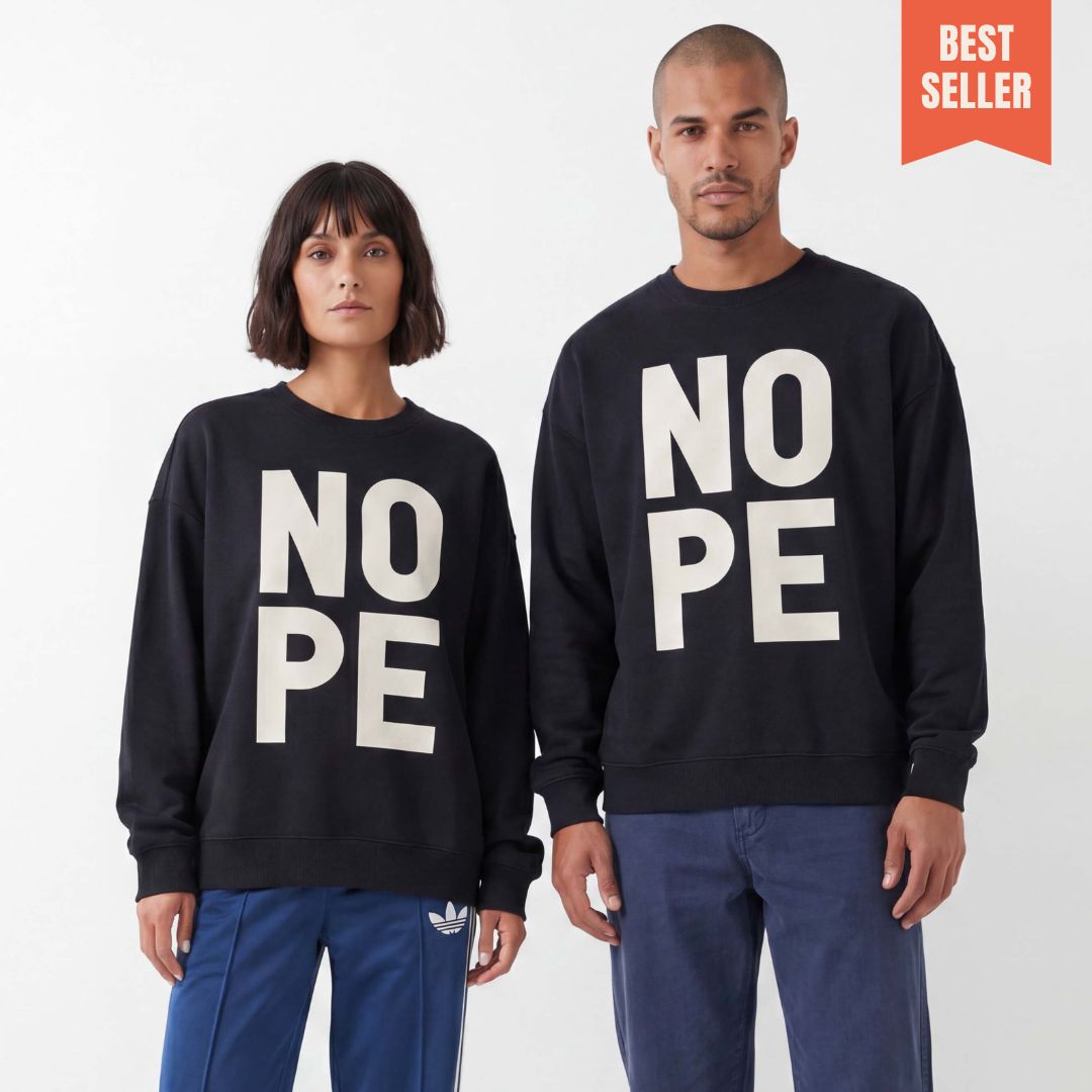 Man and woman wearing unisex sweatshirt with large letters saying NOPE, shot in a minimal studio. 