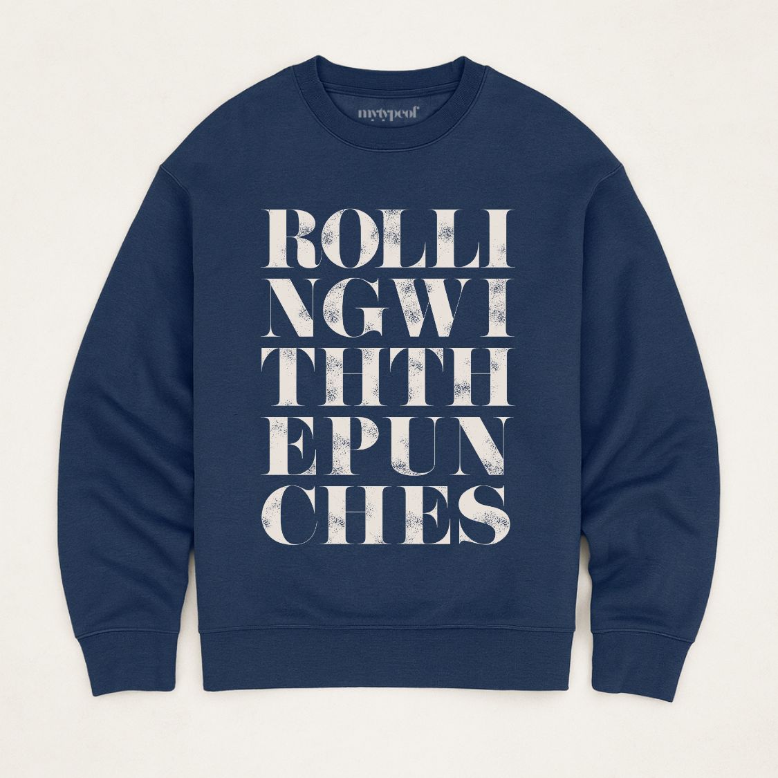 Navy unisex oversized sweatshirt with bold typographic design, 'Rolling with the punches' Photographed  as a flay lay on a plain background. 