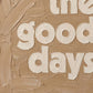 Close-up of textured oil-style typography showing thick brush strokes and layered paint detail in caramel and cream. These are the good days quote. 