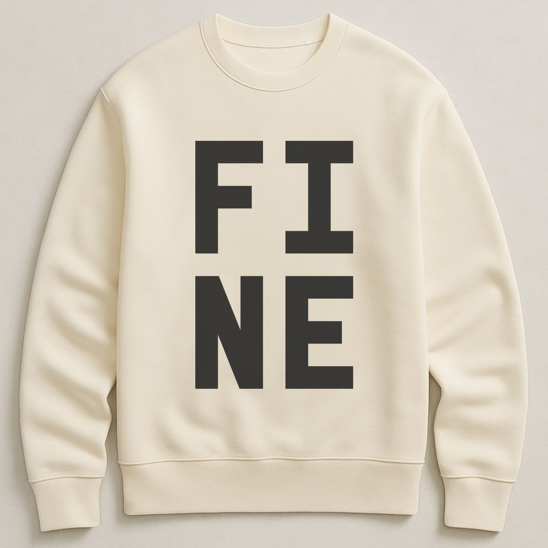 Ivory colour bold typographic designed sweatshirt, with 'FINE' design. Unisex, oversized sweatshirt, photographed  as a flay lay on a plain background. 