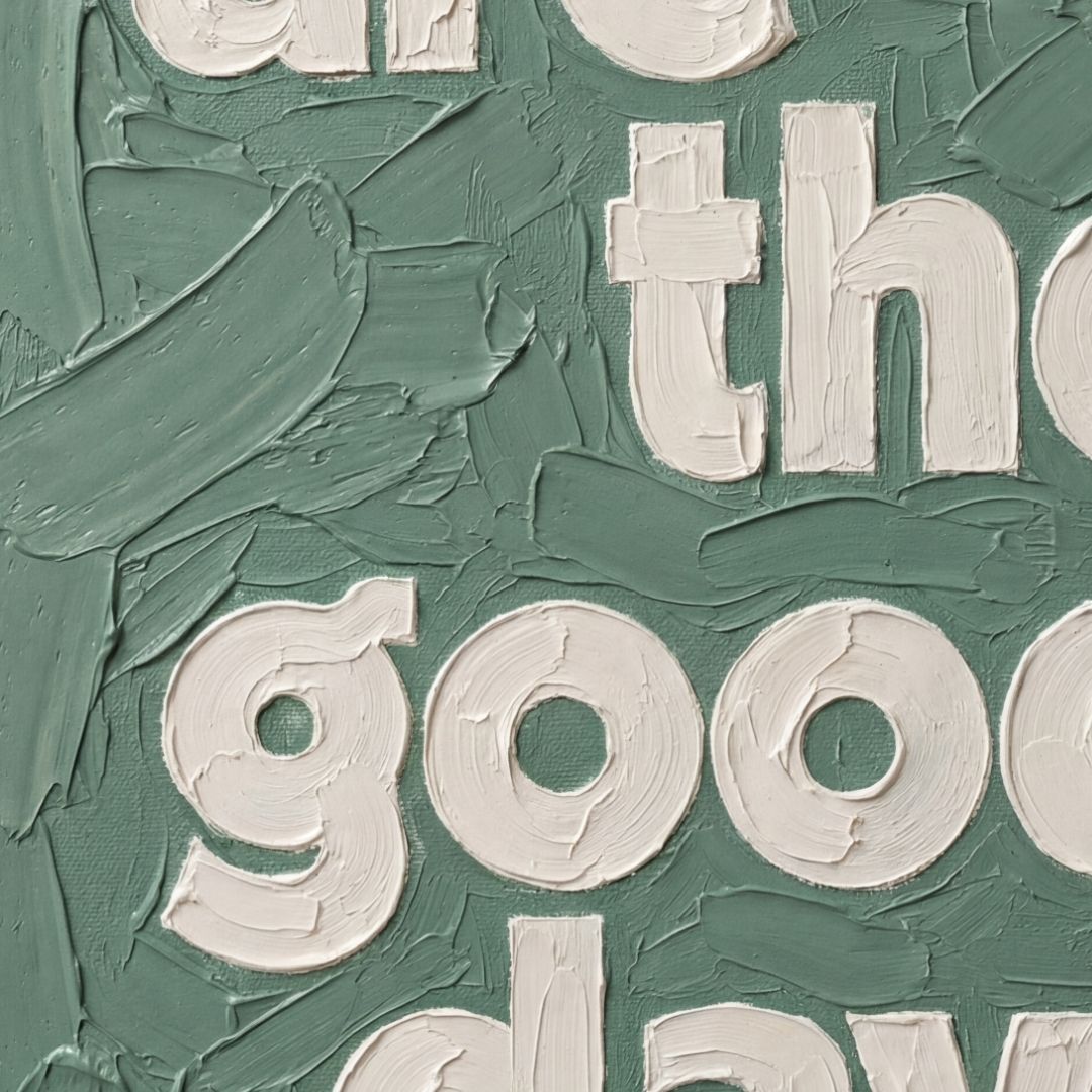 Close-up of textured oil-style typography showing thick brush strokes and layered paint detail in dusky green
. These are the good days quote. 