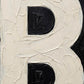 Macro shot of Letter B oil paint texture typography print on off white background