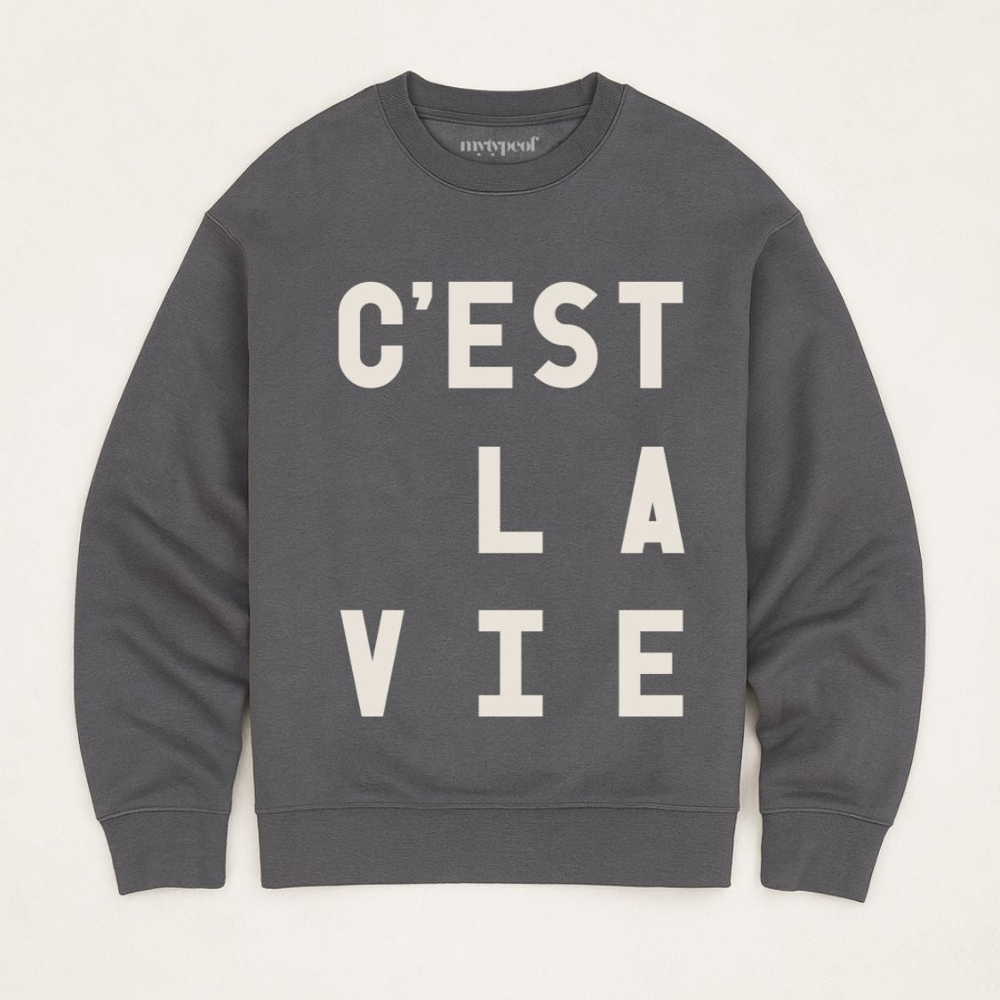 C'est La Vie unisex, oversized sweatshirt, in iron grey, flay lay photograph on a plain background. 