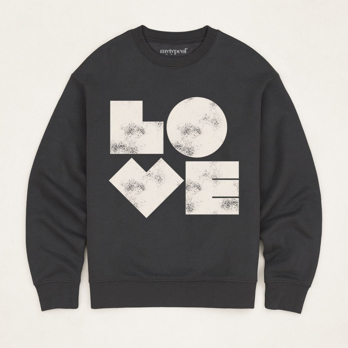 Black unisex sweatshirt with bold graphic LOVE printed in off white, flat lay shot in minimal studio. 