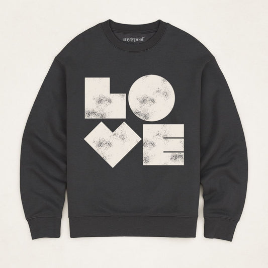 Black unisex sweatshirt with bold graphic LOVE printed in off white, flat lay shot in minimal studio. 