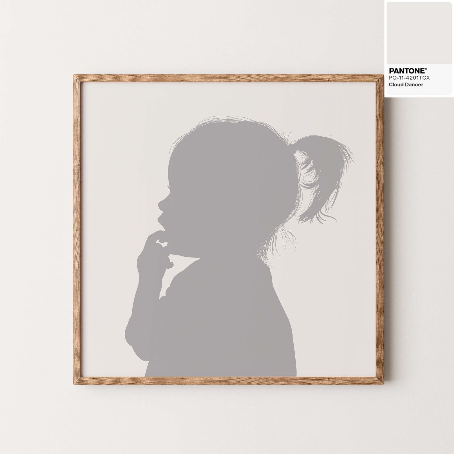 Silhouette portrait of little girl in Pantones colour of the year 2026 cloud dancer, framed in a natural wood. 