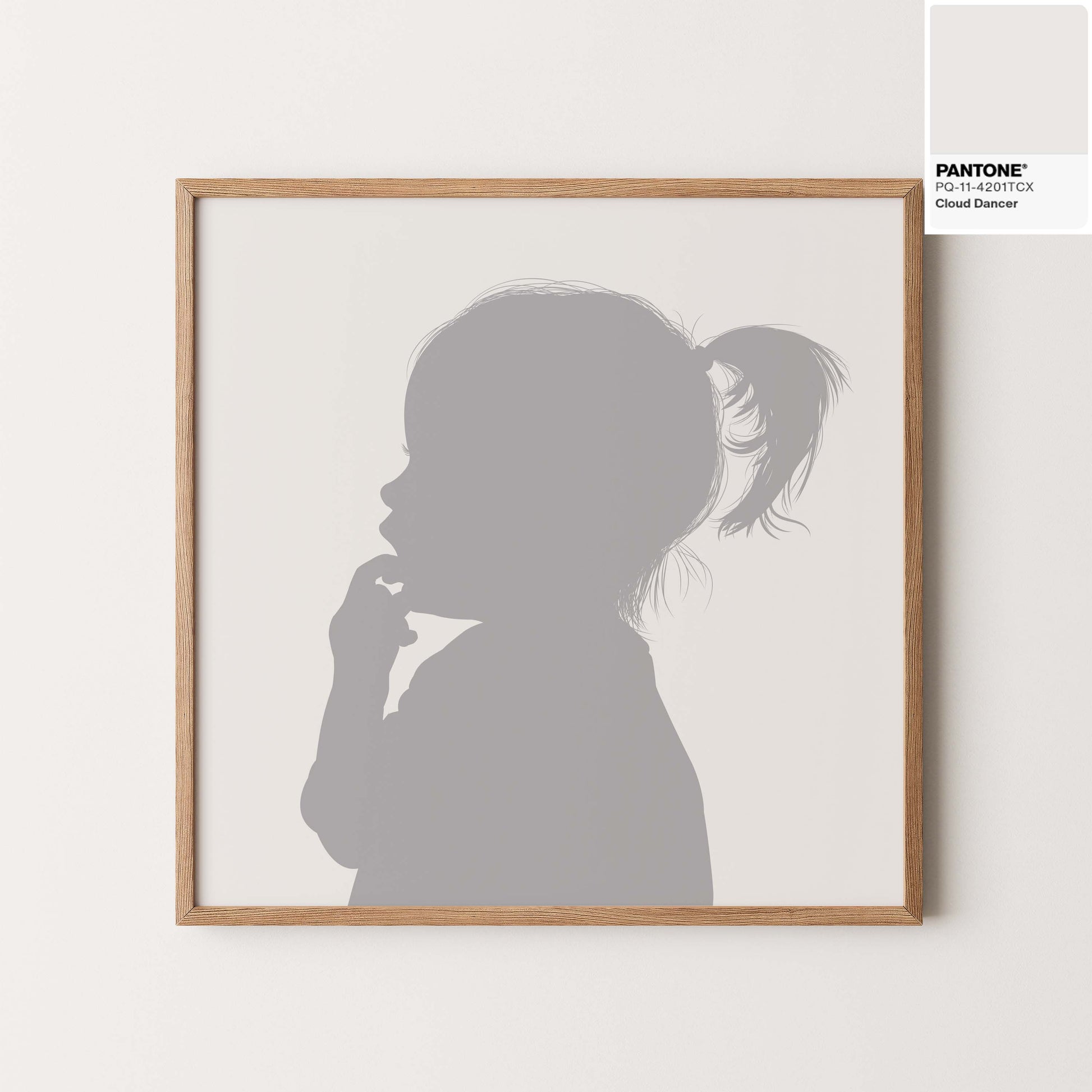 Silhouette portrait of little girl in Pantones colour of the year 2026 cloud dancer, framed in a natural wood. 