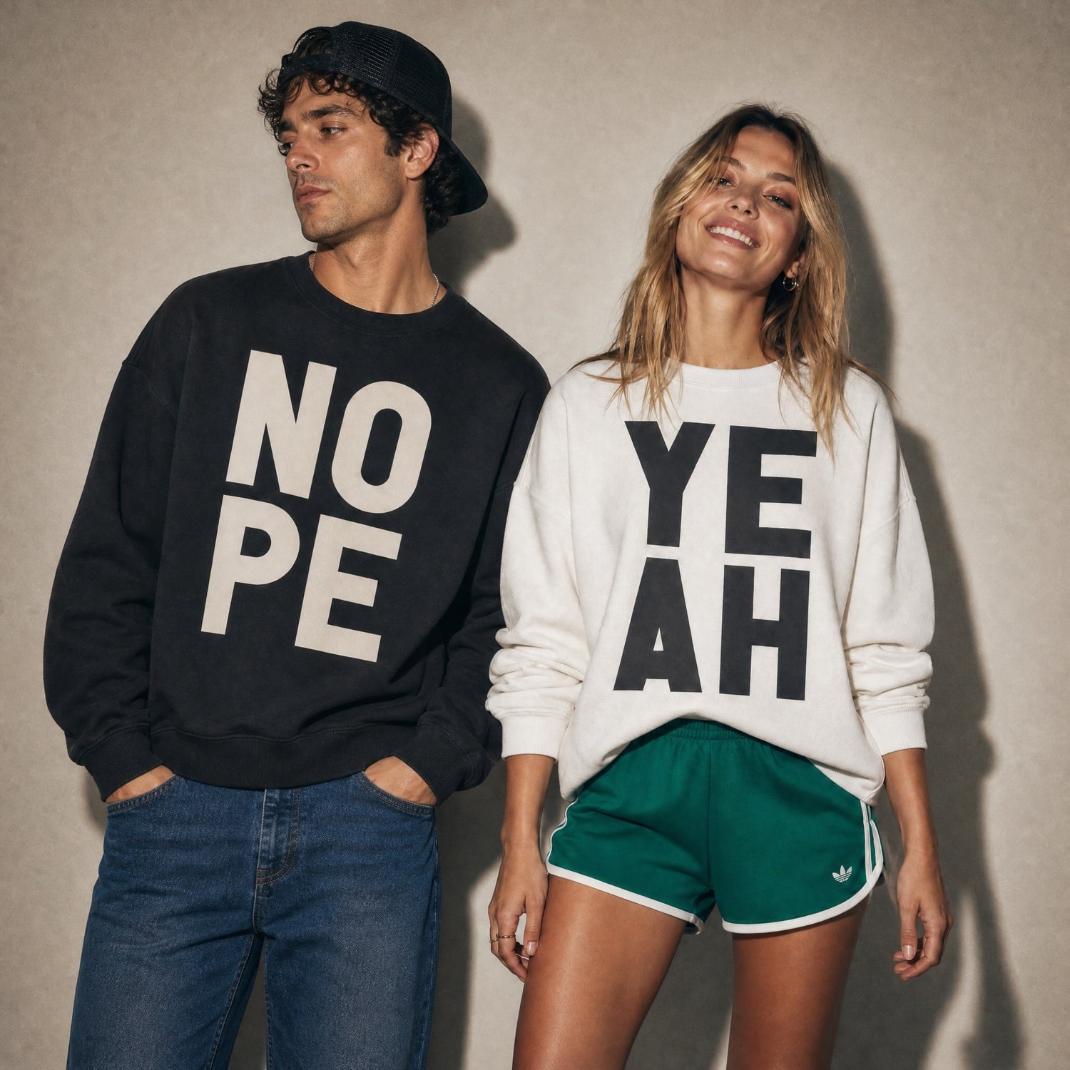 Man and woman wearing Burnt Peach NOPE and YEAH graphic sweatshirts, bold typographic streetwear