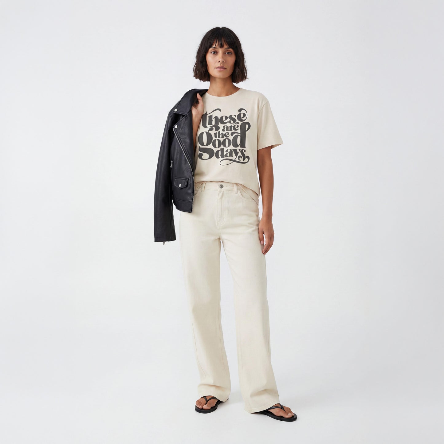 Model wearing eco raw organic  “These Are the Good Days” graphic t-shirt with ecru jeans in studio