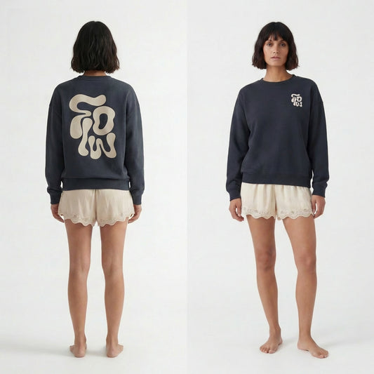 Model wearing oversized graphic sweatshirt that says FLOW on the front and back. Image showing front and back of sweatshirt, styled with lace shorts in a white studio. 