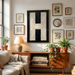 Letter H oil paint art print framed in brass on a gallery wall styled on   a mid century sideboard interior with large window