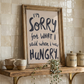 Styled in kitchen agaist cream tiles, Hangry wall art print, soft oil painted letters in charcoal colour on stone background.  Quote says "I'm sorry for what I said when I was hungry"