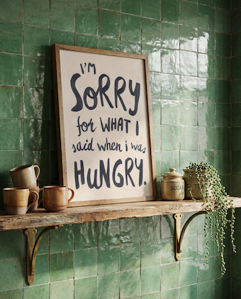Styled against green kitchen tiles. Hangry wall art print, soft oil painted letters in charcoal colour on stone background.  Quote says "I'm sorry for what I said when I was hungry"