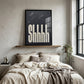 Shhh black textured bedroom wall art print in a black frame above a neutral bed in a modern minimalist bedroom.