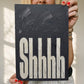 Shhh typography wall art print in black textured painted, held by woman against plain wall. Perfect for bedrooms 
