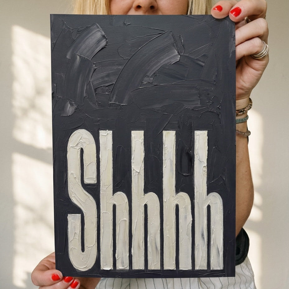 Shhh typography wall art print in black textured painted, held by woman against plain wall. Perfect for bedrooms 