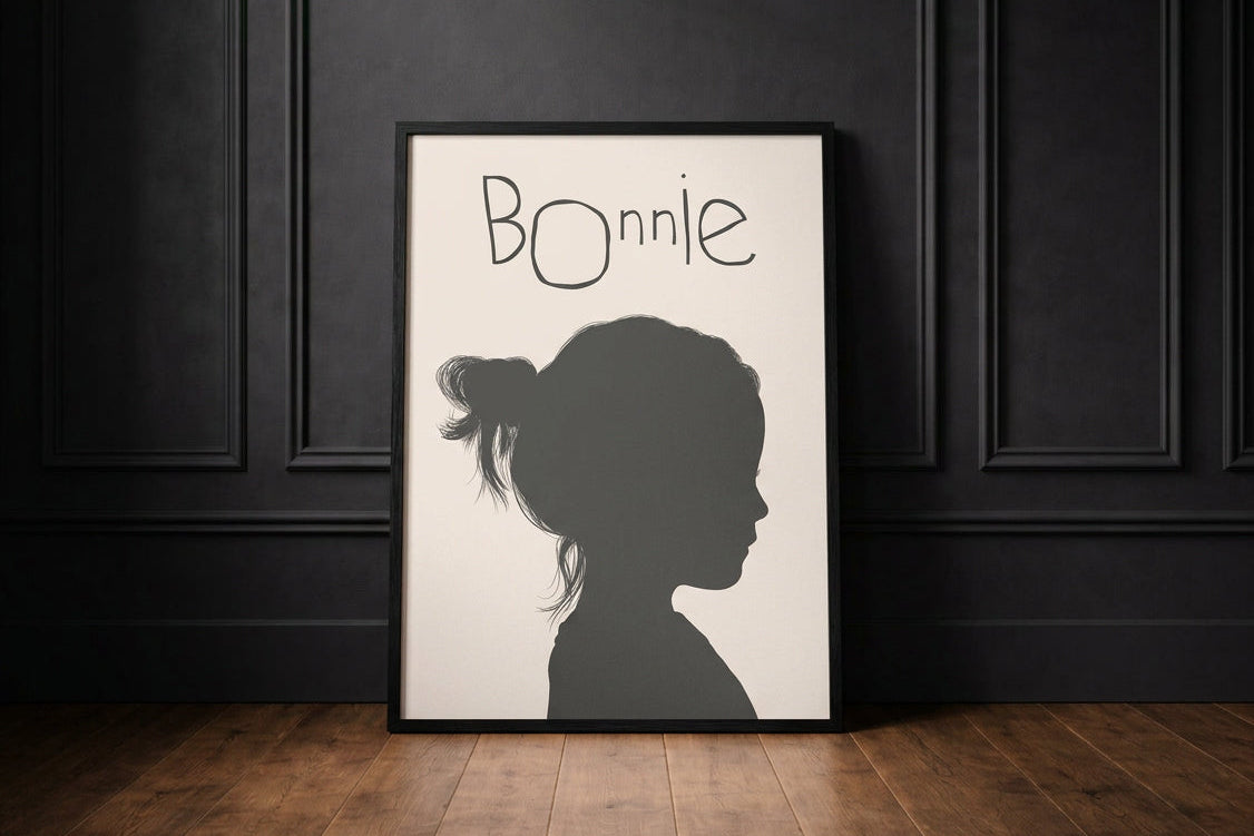 Silhouette portrait of little girl, with her signature above in Childs hand writing saying Bonnie.  framed in black leaning against black panelled wall. 