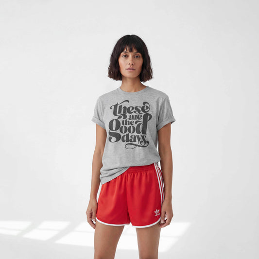 Model wearing these are the good days, tshirt in grey with red adidas shorts, in a minimalst studio
