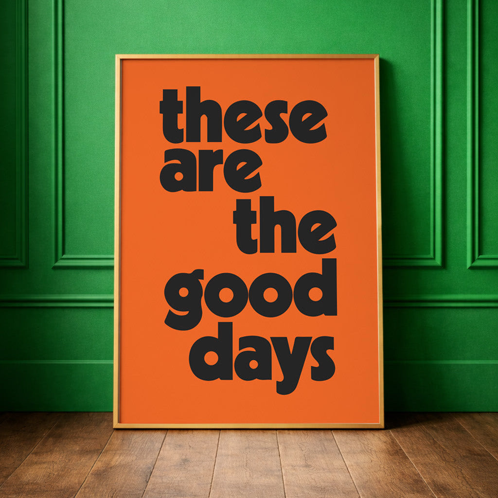 Bright orange bold typographic quote print framed against a green wall. "these are the good days" positive uplifting quote for modern colourful 
interiors. 