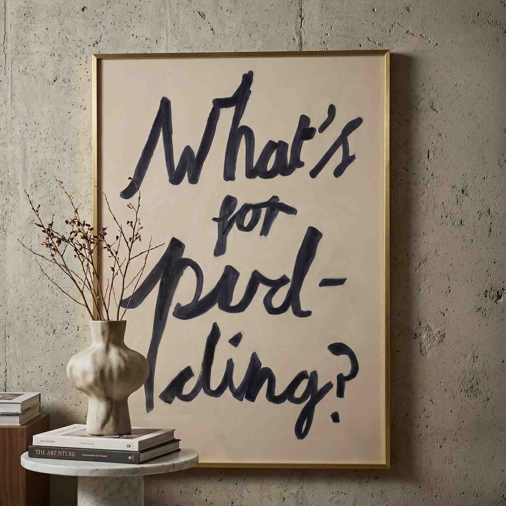 What's for pudding print in oli paint on paper framed in brass against a concrete wall. 