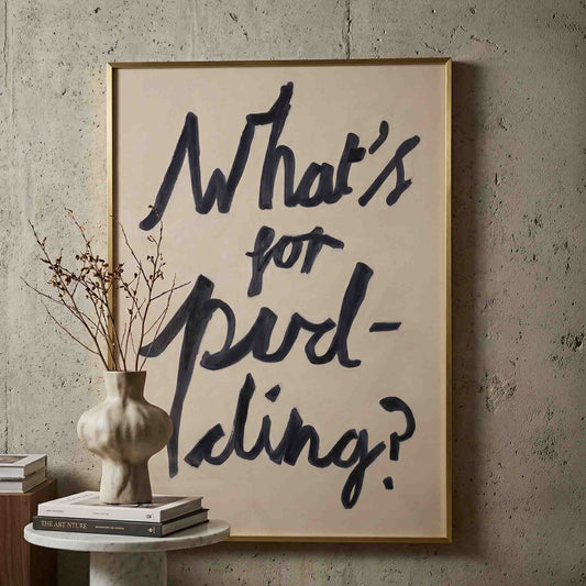 What's for pudding print in oli paint on paper framed in brass against a concrete wall. 