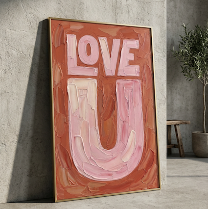 Love U typography created in oil paint, in pinks and orange, framed in brass leaning agaist a concrete  wall. 